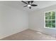 Cozy bedroom features neutral carpet, a ceiling fan, and a window, creating a relaxing atmosphere at 5229 Tarrywood Ln, Charlotte, NC 28205