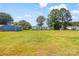 Large grassy backyard featuring a single-story home, storage building and mature trees on a sunny day at 5354 Sherrills Ford Rd, Catawba, NC 28609