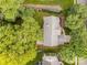 Aerial view of a home with a well-maintained roof, lush trees, and landscaping at 5707 Fairvista Dr, Charlotte, NC 28269