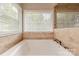 Bright bathroom featuring a soaking tub with tile surround and a large window at 5707 Fairvista Dr, Charlotte, NC 28269