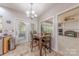 Bright breakfast nook features a dining table, chandelier and access to the living room and outdoor patio at 5707 Fairvista Dr, Charlotte, NC 28269