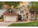 Charming two-story brick home with tan siding, manicured lawn, and inviting front entrance at 5707 Fairvista Dr, Charlotte, NC 28269
