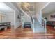 Grand foyer featuring hardwood floors, staircase with wrought iron spindles, and ample natural light at 5707 Fairvista Dr, Charlotte, NC 28269