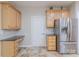 Charming kitchen featuring wooden cabinets, stainless steel refrigerator, and granite countertops, blending style and functionality at 5707 Fairvista Dr, Charlotte, NC 28269