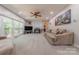 Cozy living room with a fireplace, large windows, and comfortable seating, ideal for relaxation and entertainment at 5707 Fairvista Dr, Charlotte, NC 28269