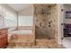 Luxurious main bathroom features a tiled shower, tiled soaking tub and large window at 5707 Fairvista Dr, Charlotte, NC 28269