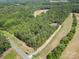 Aerial view showcasing a home amidst a dense forest, accessible via a long driveway and country road at 5720 Enochville School Rd, Kannapolis, NC 28081