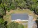 Aerial view of a home with gray roof surrounded by lush forest, with a driveway and wooden decks at 5720 Enochville School Rd, Kannapolis, NC 28081