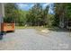 Backyard boasting a spacious gravel area, wooden deck, and play set amidst lush greenery at 5720 Enochville School Rd, Kannapolis, NC 28081