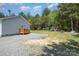 Spacious backyard featuring a wooden deck, gravel area and play set, surrounded by lush greenery at 5720 Enochville School Rd, Kannapolis, NC 28081
