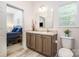 A bathroom with a double vanity sink, a large mirror, and a connecting door to the main bedroom at 5720 Enochville School Rd, Kannapolis, NC 28081