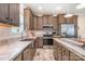 A kitchen featuring stainless steel appliances, a farmhouse sink, and light countertops with a wooden backsplash at 5720 Enochville School Rd, Kannapolis, NC 28081