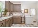 Laundry room equipped with wooden cabinets and sink, paired with wood-look floors and an open freezer at 5720 Enochville School Rd, Kannapolis, NC 28081
