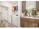 Functional laundry room with washer, sink, and ample cabinet space for storage, plus access to bathroom at 5720 Enochville School Rd, Kannapolis, NC 28081