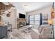 A living room with a stacked stone fireplace, light wood flooring, and multiple seating options at 5720 Enochville School Rd, Kannapolis, NC 28081
