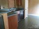 A kitchen features a stainless steel double sink, a dishwasher, wood cabinets, and green tile flooring at 5727 Dockside Dr, Charlotte, NC 28227