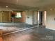 Open-concept living room with mirrors, access to kitchen, and doorways to other rooms at 5727 Dockside Dr, Charlotte, NC 28227
