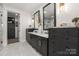 Bathroom with dual vanity, marble countertops, dark cabinets, and large mirror at 5888 Wood Duck Way, Catawba, NC 28609
