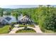 Beautiful exterior view of tan home with manicured landscaping, circular driveway and lake in the background at 5888 Wood Duck Way, Catawba, NC 28609