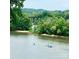 Picturesque water view with people kayaking, surrounded by lush green trees at 5888 Wood Duck Way, Catawba, NC 28609