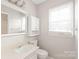 Bright bathroom with vanity, mirror, storage, and window at 5949 Quail Hollow Rd # E, Charlotte, NC 28210