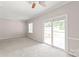 Bright bedroom featuring a ceiling fan and sliding glass doors to the outside at 5949 Quail Hollow Rd # E, Charlotte, NC 28210