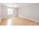 Spacious bedroom with wood floors, ceiling fan, and natural light at 5949 Quail Hollow Rd # E, Charlotte, NC 28210
