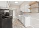 Bright kitchen features white cabinets, stainless steel appliances, and open shelving at 5949 Quail Hollow Rd # E, Charlotte, NC 28210
