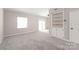 Spacious living room with built-in shelving, ceiling fan, and sliding doors to the outside at 5949 Quail Hollow Rd # E, Charlotte, NC 28210