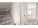 Neutral staircase with carpeted steps and a white door on the mid-level landing at 5949 Quail Hollow Rd # E, Charlotte, NC 28210