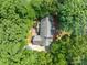 Aerial view of home surrounded by dense trees with a patio and extended driveway at 654 9Th N St, Albemarle, NC 28001