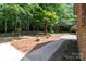 Lush backyard featuring mature trees, a quaint brick walkway, and serene landscaping at 654 9Th N St, Albemarle, NC 28001
