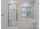 Bright bathroom featuring a shower with glass door and a large soaking tub at 654 9Th N St, Albemarle, NC 28001