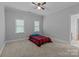Neutral bedroom with carpet flooring, a ceiling fan, and two windows for natural light at 654 9Th N St, Albemarle, NC 28001
