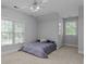 Cozy bedroom with neutral walls, carpet flooring, two windows, and a ceiling fan at 654 9Th N St, Albemarle, NC 28001