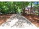 Long, private driveway leading to a brick home surrounded by mature trees at 654 9Th N St, Albemarle, NC 28001