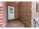Brick entryway with a white door and garden hose at 654 9Th N St, Albemarle, NC 28001