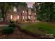 Beautiful brick home with manicured lawn and elegant landscaping at dusk at 654 9Th N St, Albemarle, NC 28001