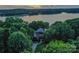 Beautiful waterfront home surrounded by lush greenery with a lake view at sunset at 7221 High Point Ct, Charlotte, NC 28278