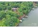 Aerial view featuring waterfront home with lush landscaping and private boat docks on the lake at 7221 High Point Ct, Charlotte, NC 28278