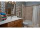 Full bathroom with a vanity, framed mirror, patterned wallpaper, and a shower-tub combination at 7221 High Point Ct, Charlotte, NC 28278