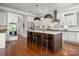 Modern kitchen featuring white cabinets, a large island with seating, and stainless steel appliances at 7221 High Point Ct, Charlotte, NC 28278
