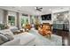 Inviting living room with white sofa, leather chairs, fireplace, built-in bar, and large windows overlooking the backyard at 7221 High Point Ct, Charlotte, NC 28278