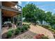 Brick patio and lakeside lawn with comfortable seating, fire pit and verdant foliage at 7221 High Point Ct, Charlotte, NC 28278
