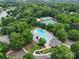 Aerial view showcasing the community pool, clubhouse, tennis courts, and lush landscaping surrounded by trees at 9137 Brightleaf Pl, Charlotte, NC 28269