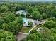 Aerial view showcasing the community pool, clubhouse, tennis courts, and lush landscaping surrounded by trees at 9137 Brightleaf Pl, Charlotte, NC 28269