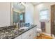 Bathroom showcasing a granite countertop, a large mirror, and a window with natural light at 9137 Brightleaf Pl, Charlotte, NC 28269