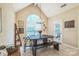 Light-filled dining area with vaulted ceilings, large arched window, dark wood table, and bench seating at 9137 Brightleaf Pl, Charlotte, NC 28269