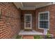 Close up of the front door area surrounded by brickwork with a window to the right at 9137 Brightleaf Pl, Charlotte, NC 28269