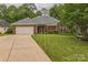 Charming single-story brick home featuring an attached two-car garage and well-maintained front lawn at 9137 Brightleaf Pl, Charlotte, NC 28269